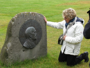 De kleindochter van J.B. Charcot, Mevrouw Anne-Marie Vallin-Charcot aan de voet van een bas-relief van Charcot in Ijsland.